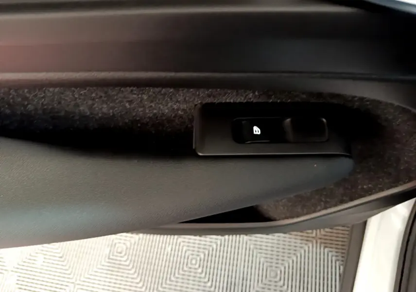 Gros plan sur le bouton de verrouillage des portes dans la portière intérieure noire du Volvo XC40 T2 2020 gris clair.