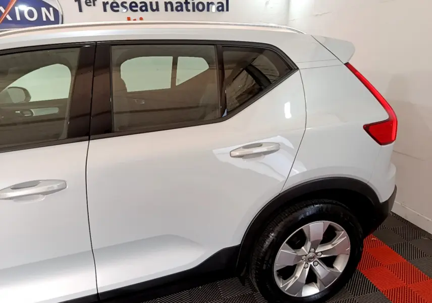 Vue côté droit arrière du Volvo XC40 T2 gris clair avec jante alliage et feux arrière LED distinctifs.