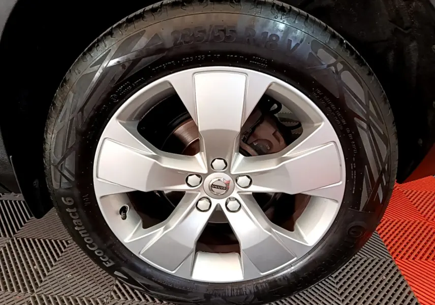 Gros plan sur la jante alliage argentée de 18 pouces du Volvo XC40 T2 Momentum gris clair, avec logo central visible.