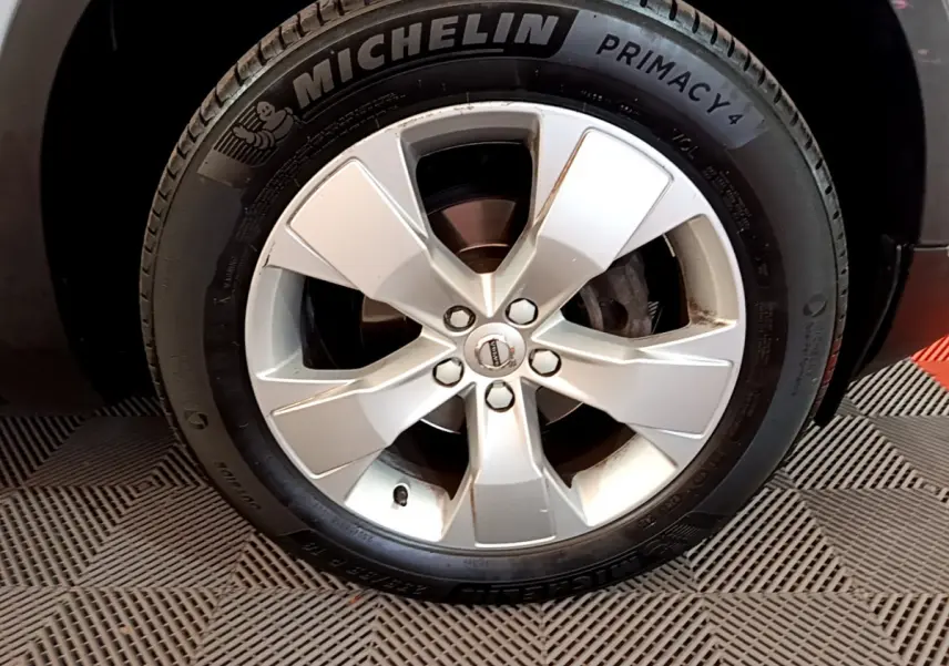Gros plan sur la roue avant droite d'un Volvo XC40 gris clair, avec jante alliage et pneu Michelin Primacy 4.