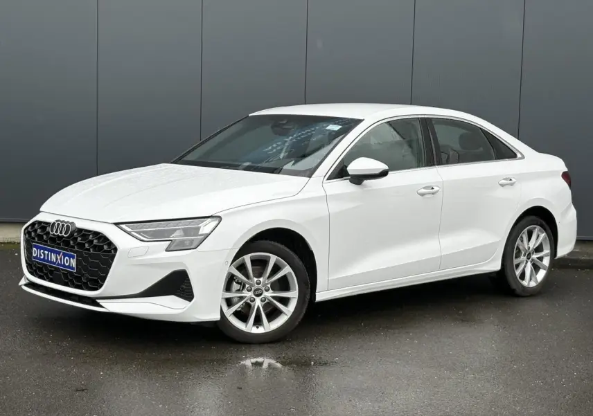 Audi A3 Berline blanc Arkona vue 3/4 avant droit, jantes alliage 17 pouces et calandre hexagonale noire.