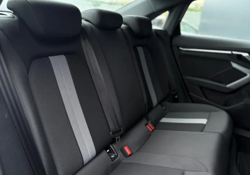 Vue latérale droite des sièges arrière noirs avec bandes grises de l'Audi A3 Berline 30 TFSI 116 S-tronic Advanced Edition 2024.