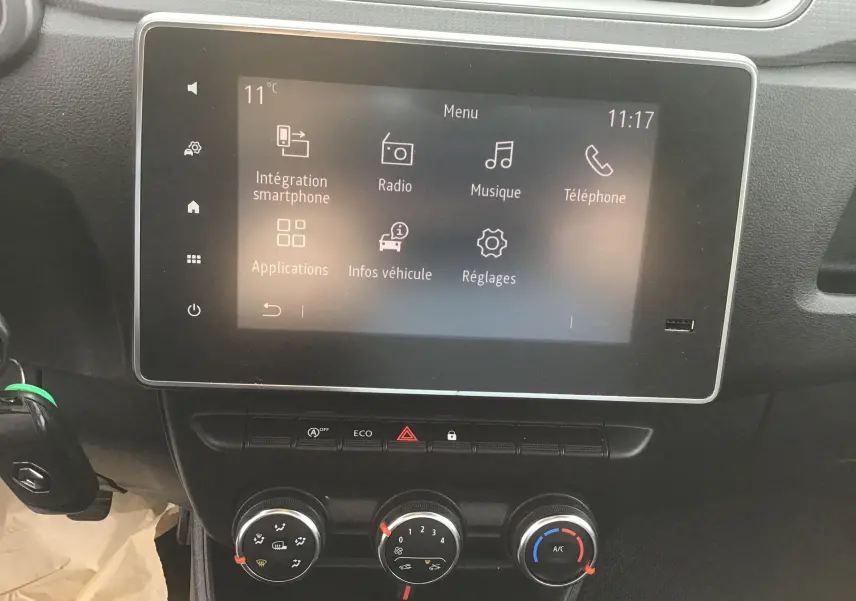 Vue rapprochée de l’écran tactile et des commandes de climatisation du tableau de bord du Renault Express Van blanc 2023.