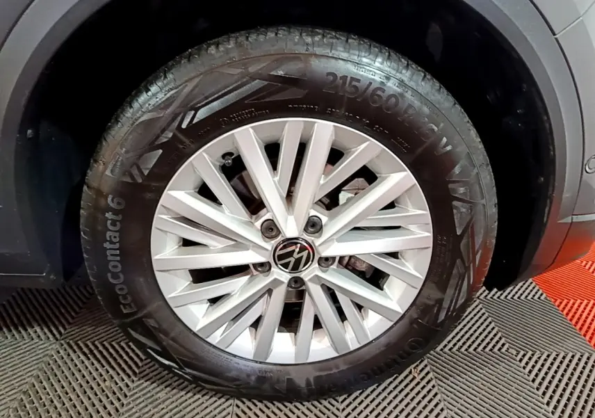 Gros plan sur la roue avant droite du Volkswagen T-Roc gris foncé, jante alliage à rayons multiples.