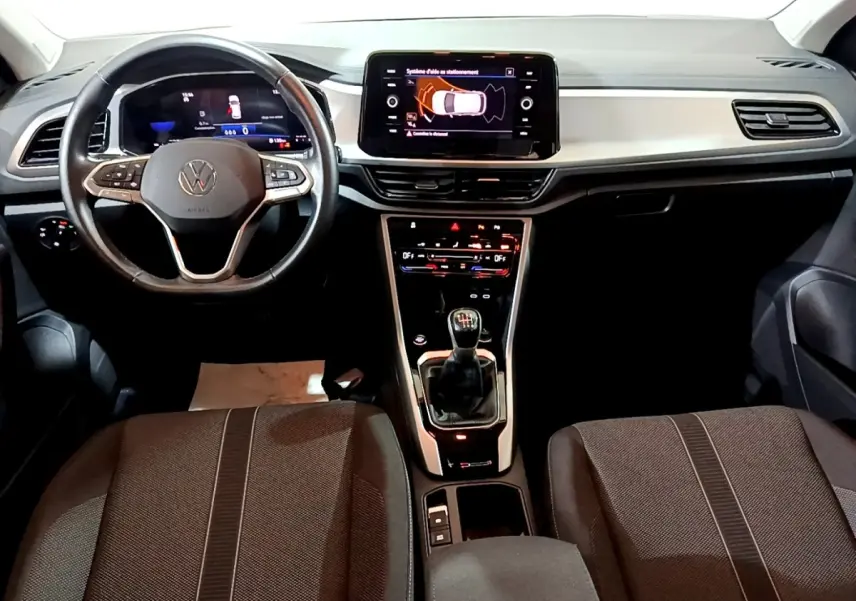 Vue intérieure avant du Volkswagen T-Roc 1.0 TSI 110 LIFE BUSINESS 2022, tableau de bord et volant cuir noir.