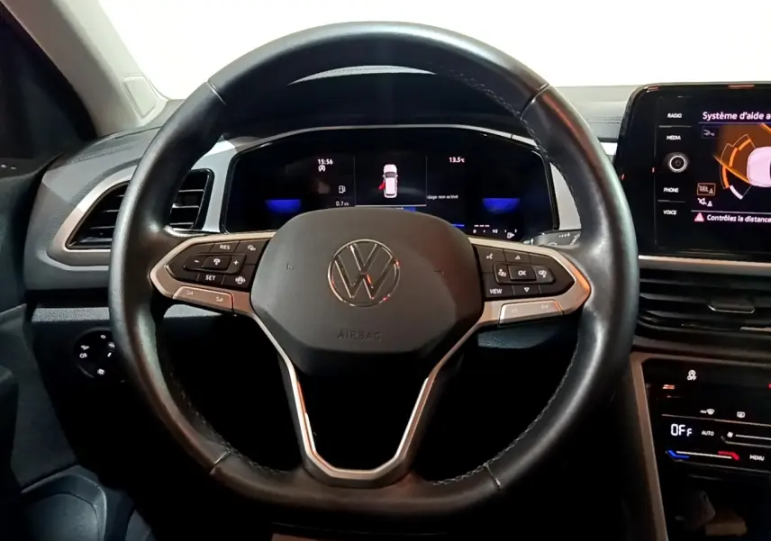 Vue intérieure centrée sur le volant cuir multifonctions d’un Volkswagen T-Roc 2022 avec tableau de bord digital.