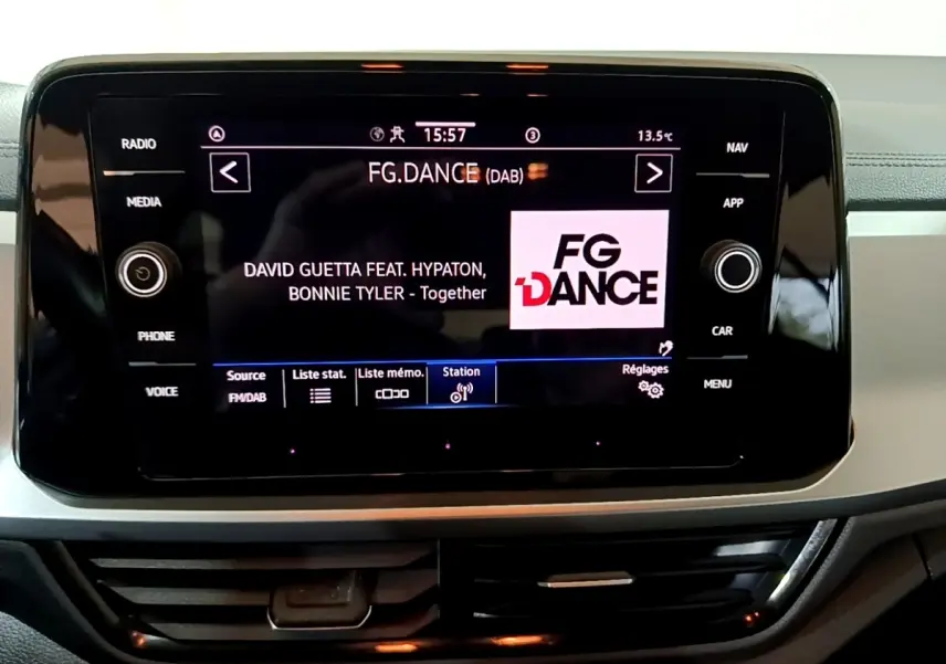 Écran tactile central affichant la radio FG.DANCE dans l'habitacle du Volkswagen T-Roc gris foncé.