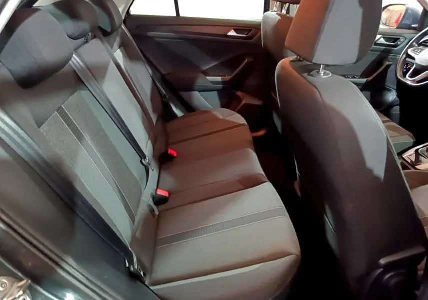 Vue intérieure arrière du Volkswagen T-Roc gris foncé 2022, banquette 3 places avec ceintures et appuie-têtes visibles.