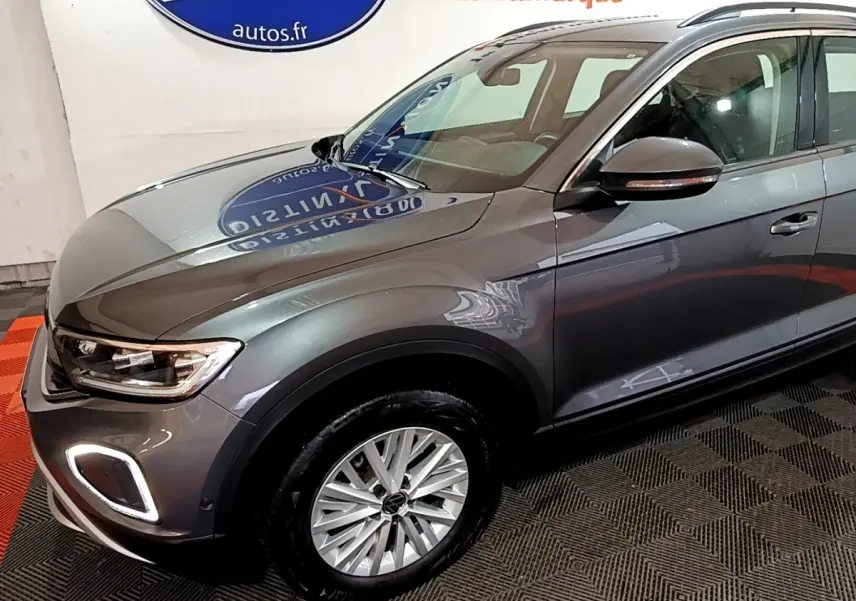 Vue 3/4 avant droit d’un Volkswagen T-Roc gris foncé avec feux LED et jantes alliage visibles.