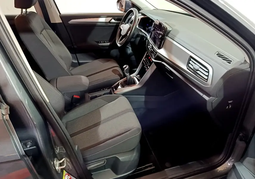 Intérieur avant droit du Volkswagen T-Roc gris foncé 2022, avec sièges tissu et tableau de bord numérique.