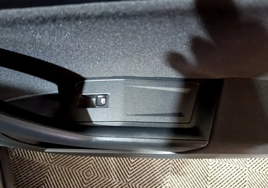 Détail de la commande de verrouillage sur la porte intérieure côté conducteur d’un Volkswagen T-Roc gris foncé 2022.