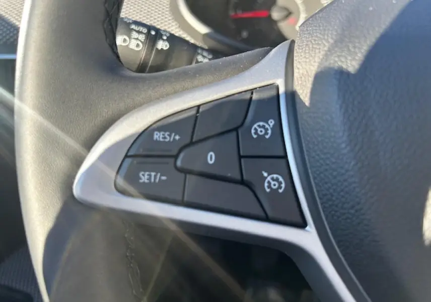 Gros plan sur les commandes de régulateur de vitesse au volant du Dacia Sandero Stepway 2025.