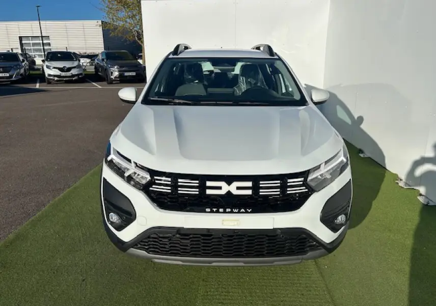 Vue avant d'une Dacia Sandero Stepway blanche Arctique avec calandre noire et signature lumineuse LED en Y.