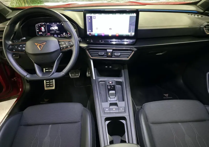 Intérieur avant du CUPRA Formentor rouge 2024, tableau de bord avec écran tactile 12", volant sport cuir et finitions Copper.