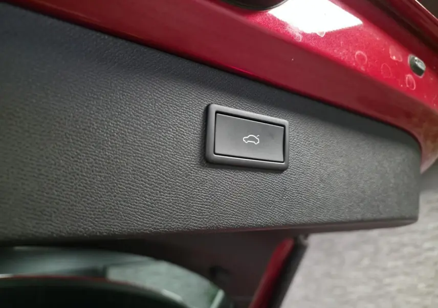 Bouton d'ouverture électrique du hayon sur la partie intérieure rouge vif du coffre arrière du CUPRA Formentor 2024.