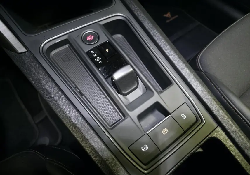 Vue rapprochée de la console centrale noire du Cupra Formentor 1.4 e-Hybrid avec levier de vitesses automatique et boutons lumineux.