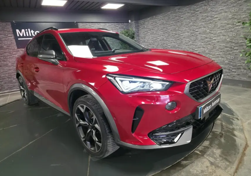 Vue 3/4 avant droite du CUPRA Formentor rouge Désir 2024 avec jantes alliage noires et calandre marquée.