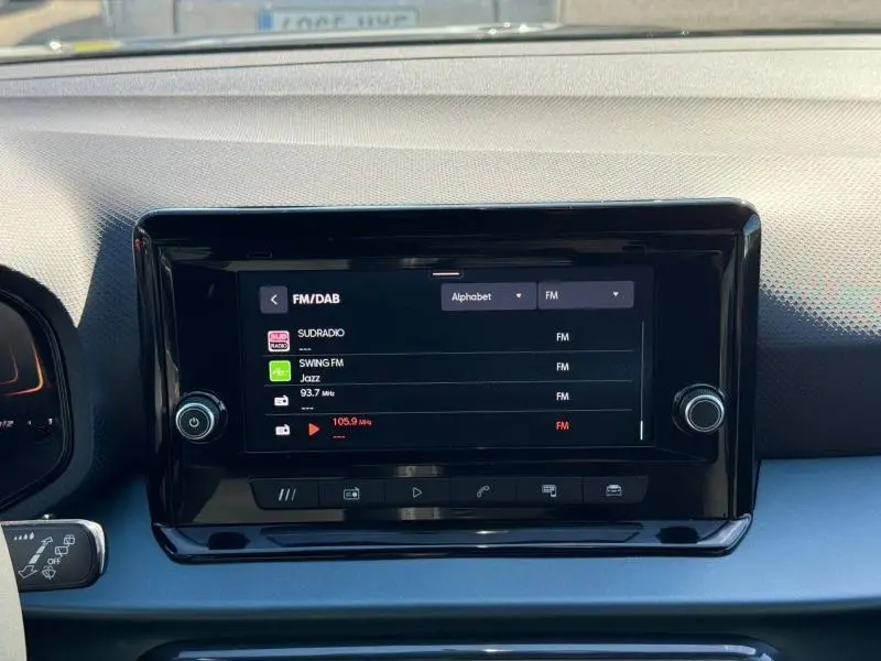 Vue rapprochée de l'écran tactile central noir du tableau de bord du SEAT Arona 2025 affichant les stations radio FM/DAB.