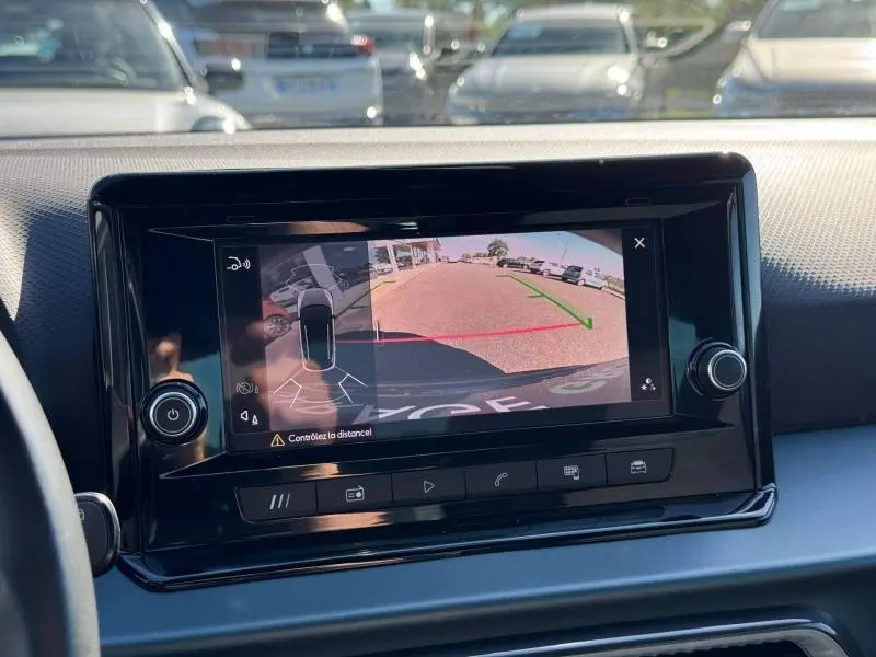 Écran tactile intérieur montrant la caméra de recul d'une SEAT Arona noire, vue depuis le poste de conduite.