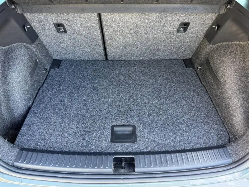 Coffre ouvert vu de face d'un SEAT Arona noir 2025, montrant un espace de chargement propre avec revêtement gris.