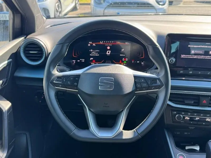 Vue frontale centrée sur le volant cuir noir du SEAT Arona 2025 avec tableau de bord numérique et écran tactile.