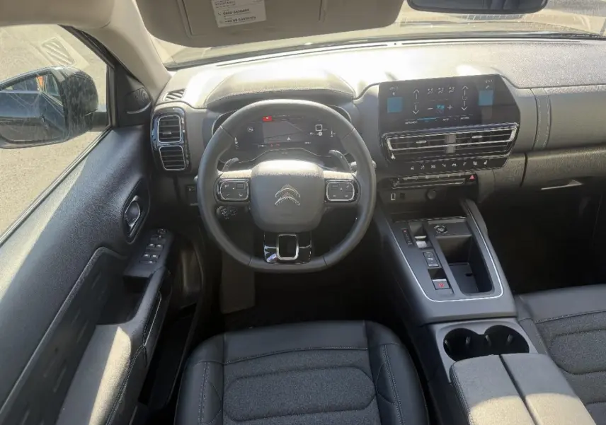 Vue intérieure frontale du tableau de bord et volant noir du Citroën C5 Aircross 2024 avec écran tactile et console centrale moderne.