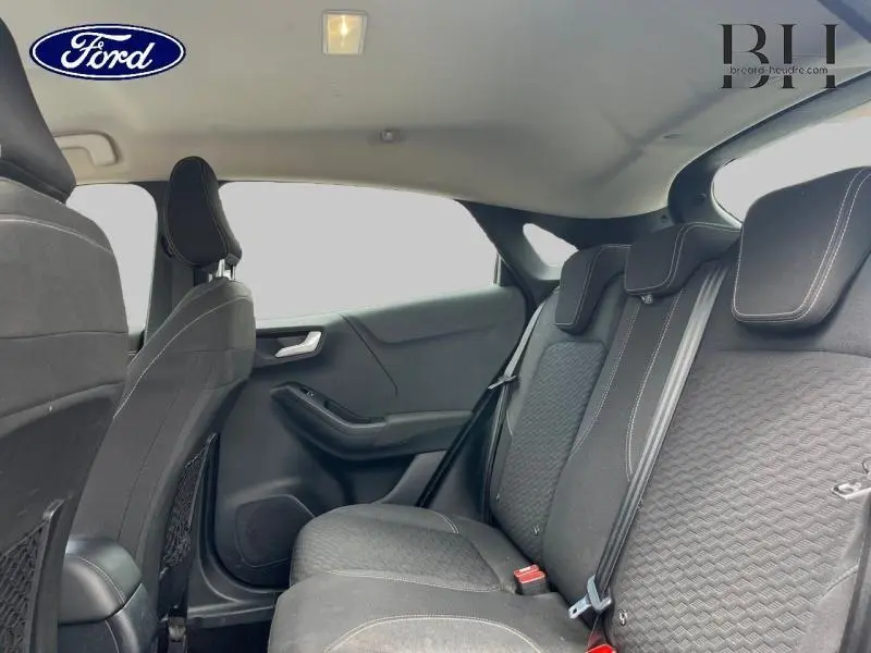 Vue intérieure arrière du Ford Puma 2022, sièges noirs avec surpiqûres blanches et appuie-têtes intégrés.