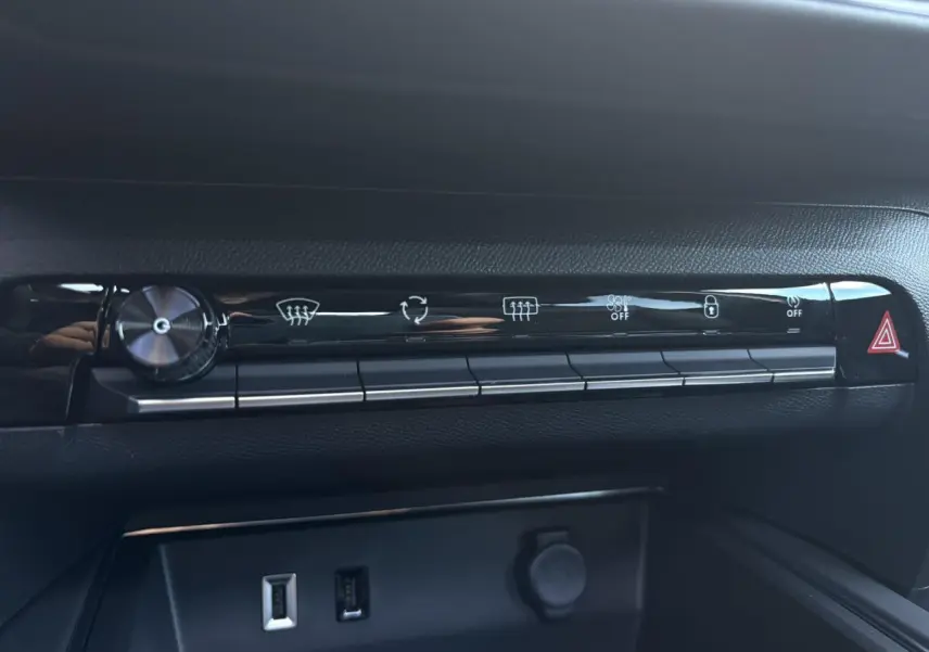 Vue rapprochée de la rangée de boutons de commande noire brillante sur la planche de bord du Citroën C5 Aircross.