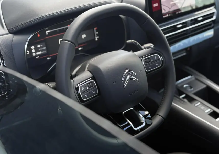 Vue rapprochée du volant noir et du tableau de bord numérique du Citroën C5 Aircross 2025, intérieur moderne et épuré.