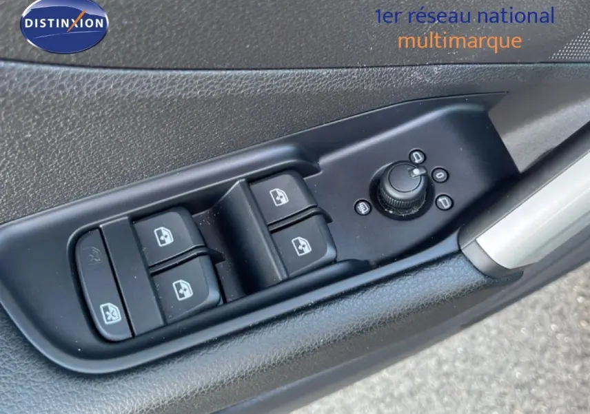 Gros plan sur les commandes des vitres et rétroviseurs côté conducteur d'une Audi Q2 noire, finition S-Line.