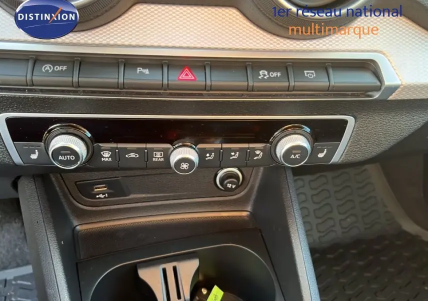 Tableau de bord et console centrale de l'Audi Q2 35 TFSI 2023, avec commandes de climatisation et ports USB visibles.