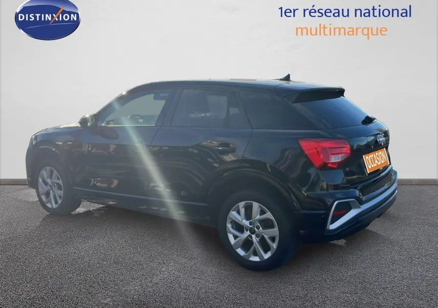 Audi Q2 noir mito metal vu de profil côté gauche, mettant en valeur ses lignes compactes et ses jantes alliage.
