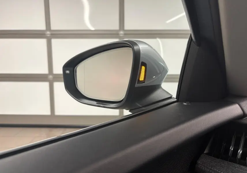 Rétroviseur extérieur côté gauche gris argent avec clignotant orange allumé sur Skoda Superb Combi 2025.