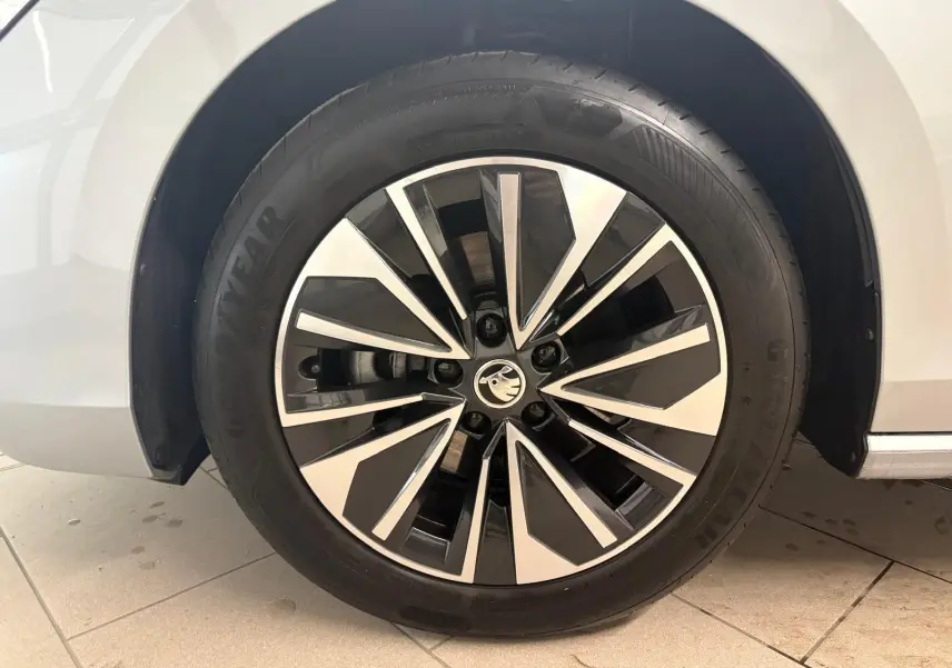Gros plan sur la roue avant droite d'une Skoda Superb Combi gris argent 2025 avec jante alliage bicolore.