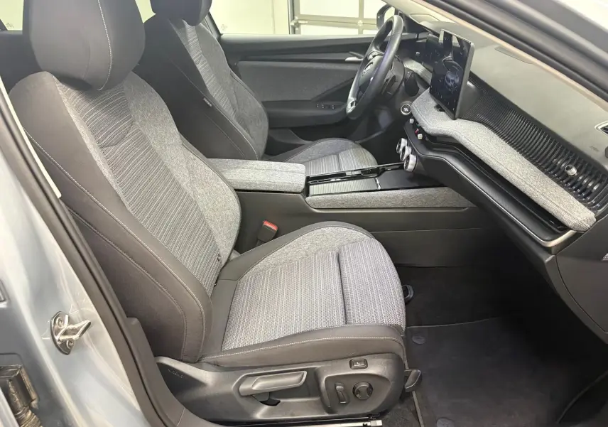 Intérieur de la Skoda Superb Combi 2025 en gris argent, vue côté conducteur montrant sièges et tableau de bord moderne.