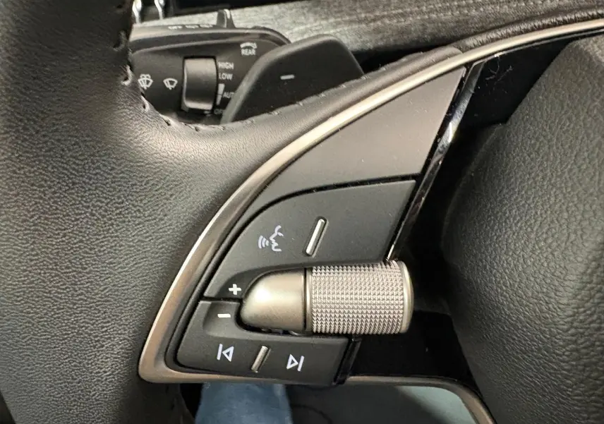 Détail du volant côté gauche du Skoda Superb Combi gris argent 2025, avec commandes audio intégrées.