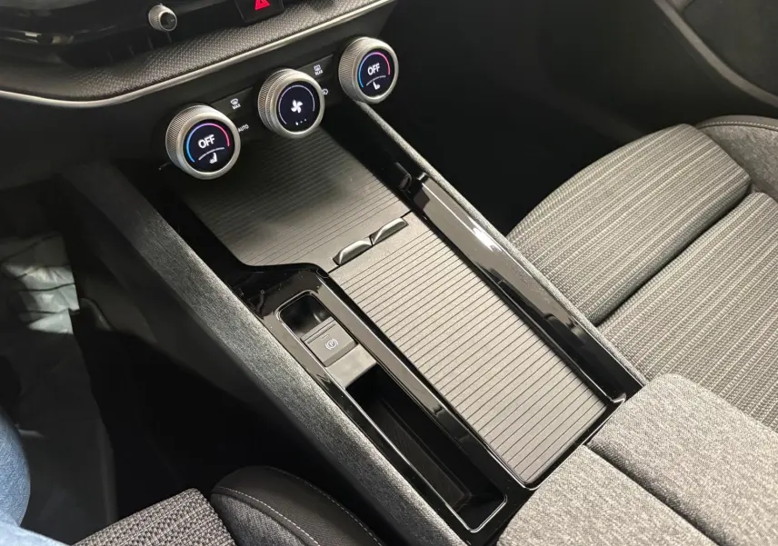 Gros plan sur la console centrale noire et les commandes de climatisation du Skoda Superb Combi gris argent 2025.
