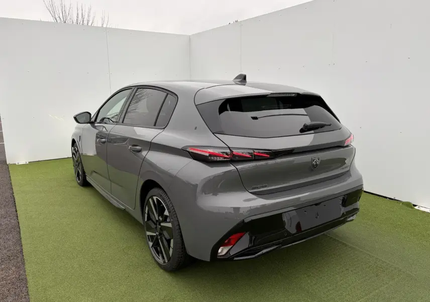 Vue 3/4 arrière droite d'une Peugeot 308 gris selenium avec feux arrière LED en forme de griffes et jantes alliage bi-tons.