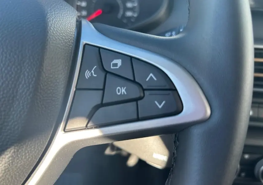 Gros plan sur les commandes multifonctions à droite du volant noir du Dacia Sandero III Stepway 2025.