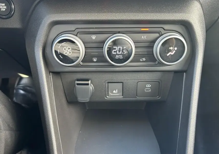 Gros plan sur la console centrale noire du Dacia Sandero Stepway 2025, montrant les commandes de climatisation digitales.