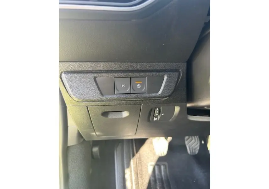 Vue intérieure côté conducteur montrant les commandes LPG et frein à main électrique sur tableau noir.