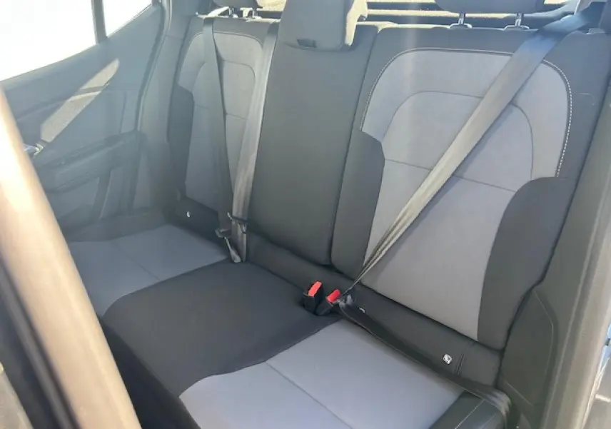 Vue intérieure de la banquette arrière bicolore grise et noire de la Dacia Sandero III Stepway 2025, avec ceintures de sécurité.