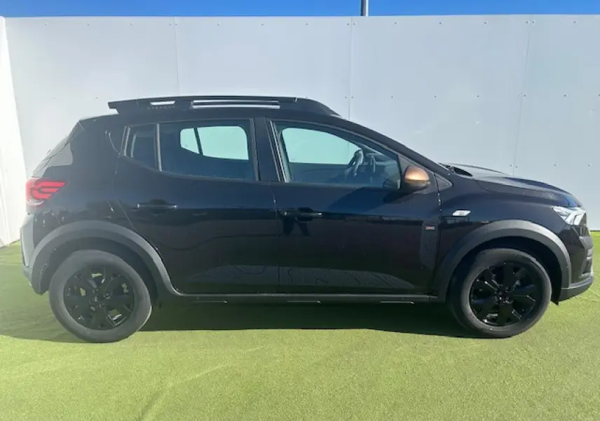 Vue profil droit d'une Dacia Sandero III Stepway noire nacrée avec jantes noires et coques de rétroviseurs brun cuivré.