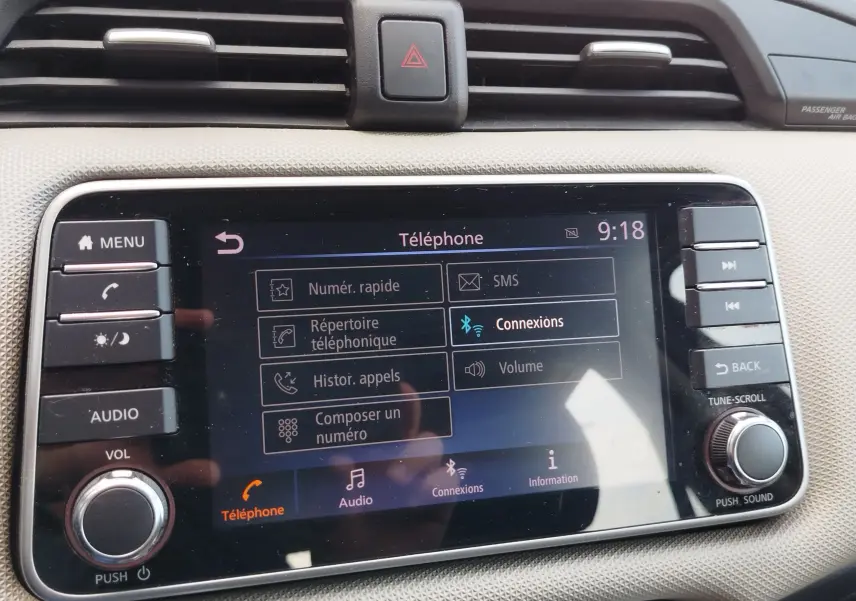 Écran tactile central du tableau de bord de la Nissan Micra blanche, affichant le menu téléphone à 9h18.