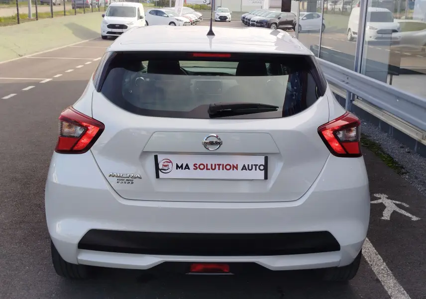 Vue arrière d'une Nissan Micra blanche 2019 avec feux arrière en forme de boomerang et logo visible sur le hayon.