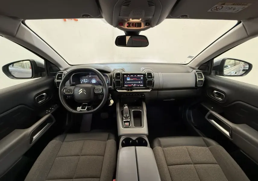 Vue intérieure avant du Citroën C5 Aircross 2020, tableau de bord moderne avec écran tactile et volant cuir multifonctions.