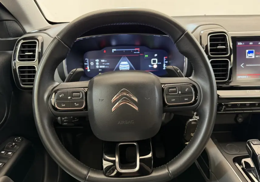 Vue rapprochée du volant cuir noir du Citroën C5 Aircross 2020 avec tableau de bord numérique et écran tactile.