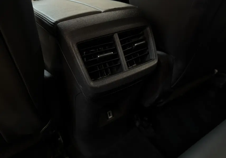 Vue rapprochée des aérateurs arrière noirs et prise USB du Citroën C5 Aircross Business gris clair, sièges en cuir noir.