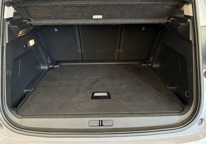 Coffre ouvert vu de l'arrière d'un Citroën C5 Aircross gris clair, espace de chargement propre et vide.