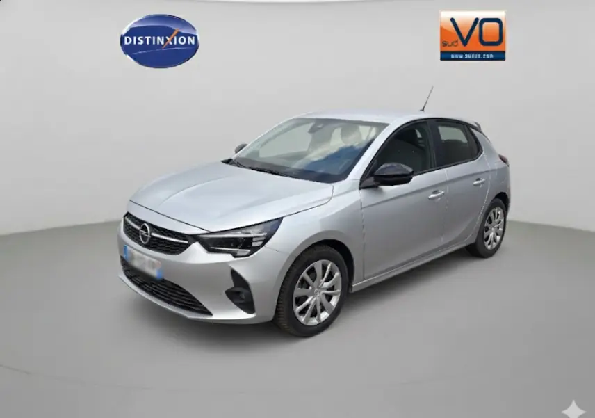 Vue 3/4 avant droite d'une Opel Corsa gris clair 2024 avec jantes classiques et rétroviseurs noirs contrastés.